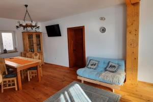 a living room with a blue couch and a table at Mura House in Vişeu de Sus