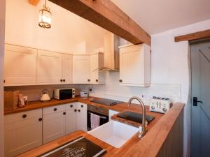 a kitchen with white cabinets and a sink at 2 bed in Conwy Valley SKN09 in Llanrwst