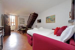 1 dormitorio con 1 cama grande y 1 sofá rojo en St.Margherita Charming House, en Roma