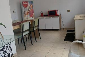 uma cozinha com uma mesa e cadeiras e um micro-ondas em casa da Déa em Mogi das Cruzes