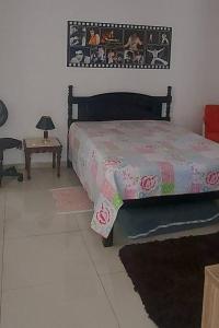 a bedroom with a bed and a table at casa da Déa in Mogi das Cruzes