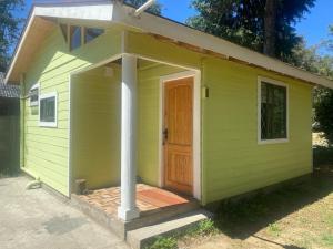 a green shed with a door and a porch at Cabañas en Valdivia in Valdivia