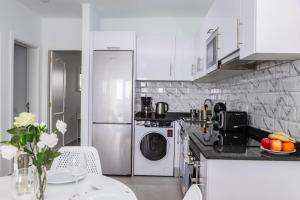 een witte keuken met een tafel, een wasmachine en een droger bij Casa Bella in Puerto del Carmen