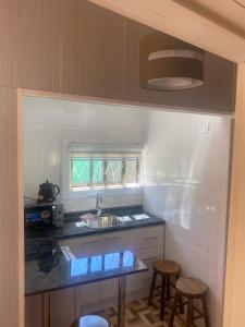 a kitchen with a sink and a counter with stools at cabaña valdivia 2 in Valdivia