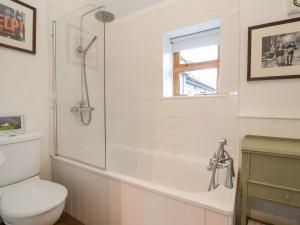 a white bathroom with a toilet and a shower at The Nook in Halesworth