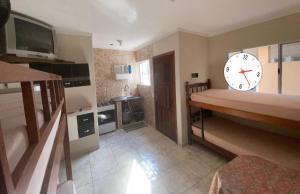 a living room with a large clock on the wall at Casa Praia Temporada Itanhaém in Itanhaém