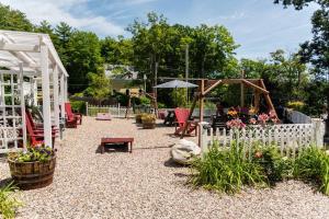 a garden with a white fence and a playground at Cottage 8-9 - Stand Alone 2 Bedroom / 2 Bath in Wolfeboro