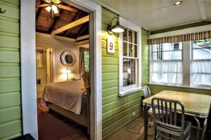 a green room with a bed and a table at Cottage 8-9 - Stand Alone 2 Bedroom / 2 Bath in Wolfeboro