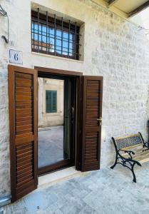 an open door with a bench in front of a building at Casa Scribano in Modica