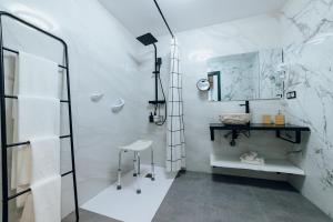 a white bathroom with a shower and a stool at HOSTAL LUXURY NIT I DIA in Altea