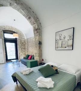 a bedroom with a bed and a couch in a room at Casa Scribano in Modica