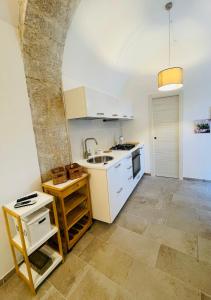 a kitchen with white cabinets and a sink at Casa Scribano in Modica
