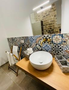 a bathroom with a white bowl sink on a wooden counter at Casa Scribano in Modica