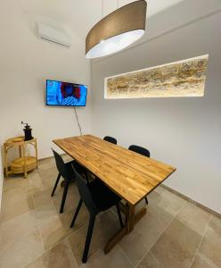 a dining room with a wooden table and chairs at Casa Scribano in Modica