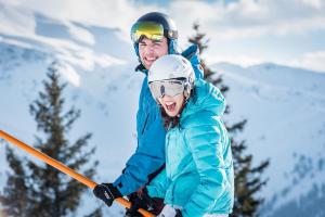 a man and a woman skiing down a snow covered slope at Ferienwohnung Maria & Luis in Kolsass