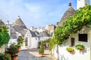 a street in a town with white buildings and vines at B&B Flower House in Fasano