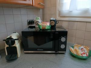 un forno a microonde su un bancone con due ciotole sopra di LELLO'S HOUSE a Torino