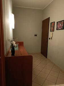 LELLO'S HOUSE في تورينو: غرفة بها مكتب مع إناء من الزهور عليه