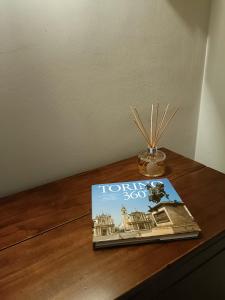 un libro seduto sopra un tavolo di legno di LELLO'S HOUSE a Torino