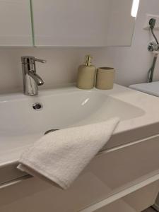 Bergkuss Brunnalm Veitsch في فيتسش: مغسلة الحمام بيضاء وعليها منشفة