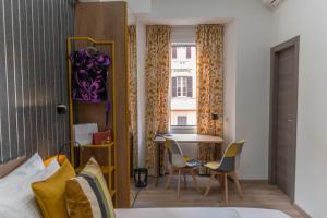 Cette chambre comprend un lit, une table et des chaises. dans l'établissement Cola Suites Apartments, à Rome
