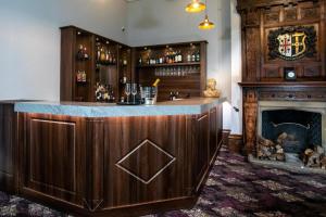 un bar in una stanza con camino di WA Hotel (Wroxall Abbey) a Wroxall