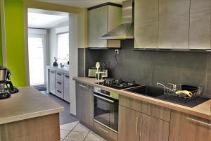 eine Küche mit Spüle und Herd Oberer Backofen in der Unterkunft gite cocoon neuf proche GERARDMER in Vienville