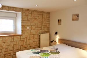 ein Schlafzimmer mit einem Bett und einer Ziegelwand in der Unterkunft gite cocoon neuf proche GERARDMER in Vienville + 16 Fotos