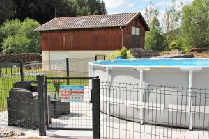 a fence with a pool in front of a building at gite cocoon neuf proche GERARDMER in Vienville