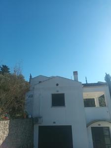 una casa blanca con un garaje delante en Thalia suite Corfu Town en Gastourion
