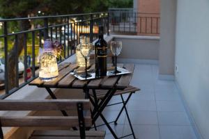 una mesa con botellas de vino y copas en el balcón en Casa Madoro, en Grottaglie