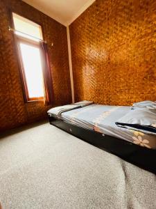 Ce lit se trouve dans une chambre dotée d'un mur en briques. dans l'établissement Villa Situ Patenggang, à Ciwidey