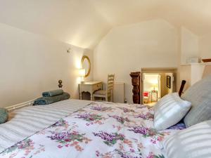 ein Schlafzimmer mit einem großen Bett mit einer Blumendecke in der Unterkunft 2 Bed in Minchinhampton 72872 in Minchinhampton