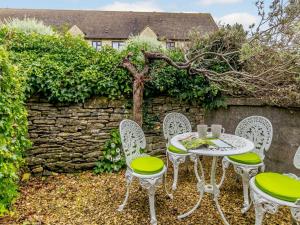 a table and chairs in front of a stone wall at 2 Bed in Minchinhampton 72872 in Minchinhampton