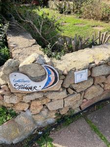 Una pared de piedra con un cartel encima. en Casetta Spinnaker, en Palau