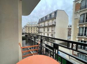 einen Balkon mit einer Bank und Stadtblick in der Unterkunft Appartement 2 pièces 57m2 Terrasse sur cour Proche Paris Porte Maillot in Levallois-Perret