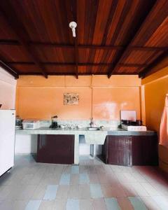 een keuken met oranje muren en een wit aanrecht bij Casa en Misahualli - Misahualli HOME in Puerto Misahuallí