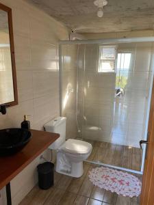 a bathroom with a shower and a toilet and a sink at Recanto Nascer do Sol in Aguas Mornas
