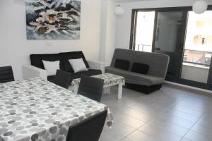 sala de estar con mesa, silla y sofá en Apartamento Capri 4 Inmomart, en Peñíscola