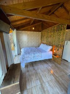 a bedroom with a bed in a room with wooden floors at Recanto Nascer do Sol in Aguas Mornas