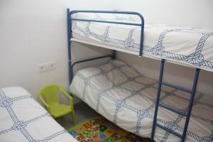 2 literas en una habitación con silla verde en Apartamento Capri 4 Inmomart, en Peñíscola