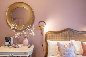 a bedroom with a bed with a mirror and a table at Boutique Home Stay Blossom in Paisley