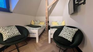 プラウエンにあるaußergewöhnliche Ferienwohnung Stadtvilla Plauenのベッド1台と鏡付きの客室内に黒い椅子2脚