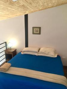 a large blue bed in a room with a night stand at LOFT JUJUY, Alto Gorritti - Departamento cerca del Centro in San Salvador de Jujuy