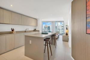 a kitchen with a counter and stools in it at Ocean View Balcony with Pool Gym Access in Hallandale Beach