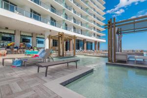 a pool at a hotel with chairs and a building at Ocean View Balcony with Pool Gym Access in Hallandale Beach