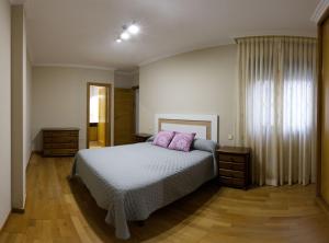een slaapkamer met een bed met 2 roze kussens bij Vacaciones en O Grove in O Grove