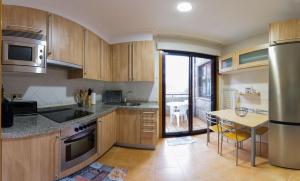 a kitchen with wooden cabinets and a table with a dining room at Vacaciones en O Grove in O Grove