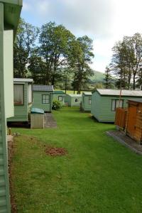 a row of mobile homes in a yard at Caravan B26 at The Woodlands in Tywyn