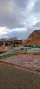 a park with benches and mountains in the background at Rum titanic camp in Wadi Rum